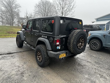 New BFGoodrich tires and custom wheels installed on a Jeep by Hill Top Tire, including a spare tire and wheel on the back